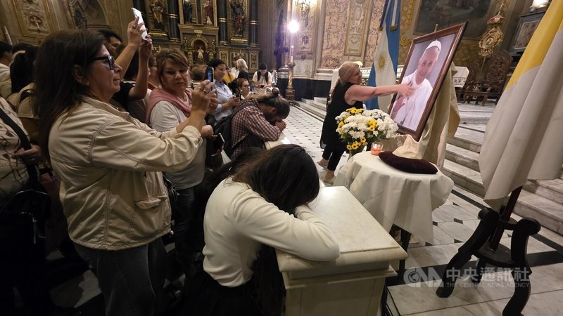 參與紀念已故教宗方濟各彌撒的阿根廷民眾，在教堂祭壇前的方濟各照片前靜默祈禱。中央社記者黃韻如布宜諾斯艾利斯攝　115年4月22日