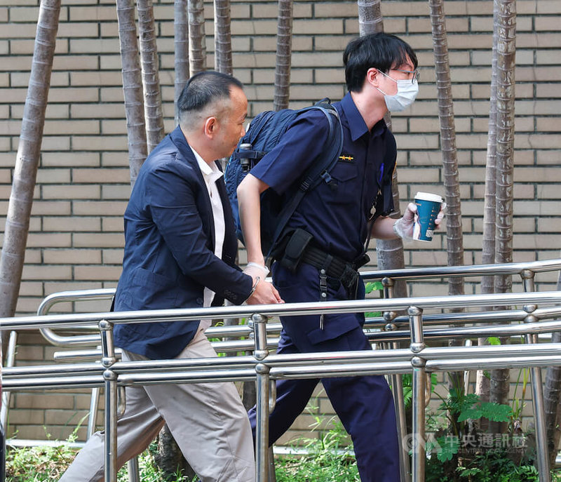 雲云科技負責人曾志新涉殺害梁姓技術長案，台北地方法院國民法官法庭22日開庭審理。曾志新（左）在法警戒護下，準備出庭。中央社記者謝佳璋攝 115年4月22日