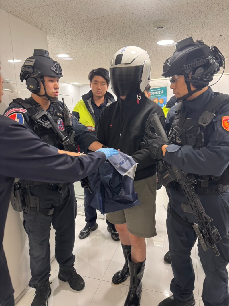 林姓男子(右2)24日持BB槍及假手榴彈赴位於台北市大安區的中國信託銀行行搶,行員機警報警,林男被趕赴現場大批警力壓制帶回。警方初查,林男疑因經濟壓力犯案,無共犯。(警方提供)中央社記者劉建邦傳真 115年4月24日