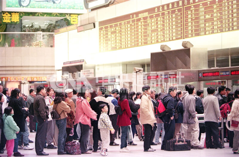 1999年2月13日春節連續假期首日，台北車站售票窗口有大批等待買票返鄉的民眾。背景可見二樓金華百貨字樣。（中央社檔案照片）