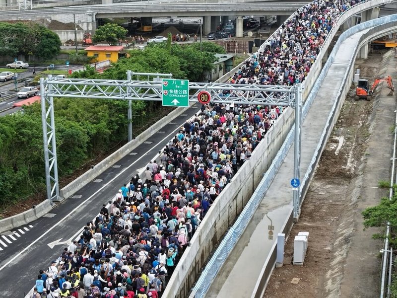 新北市府民政局25日舉辦淡江大橋通車前健行暖身活動，吸引綿延的人龍上橋。圖為健行民眾以雙腳體驗重大公共建設。（新北市府民政局提供）中央社記者黃旭昇傳真 115年4月25日