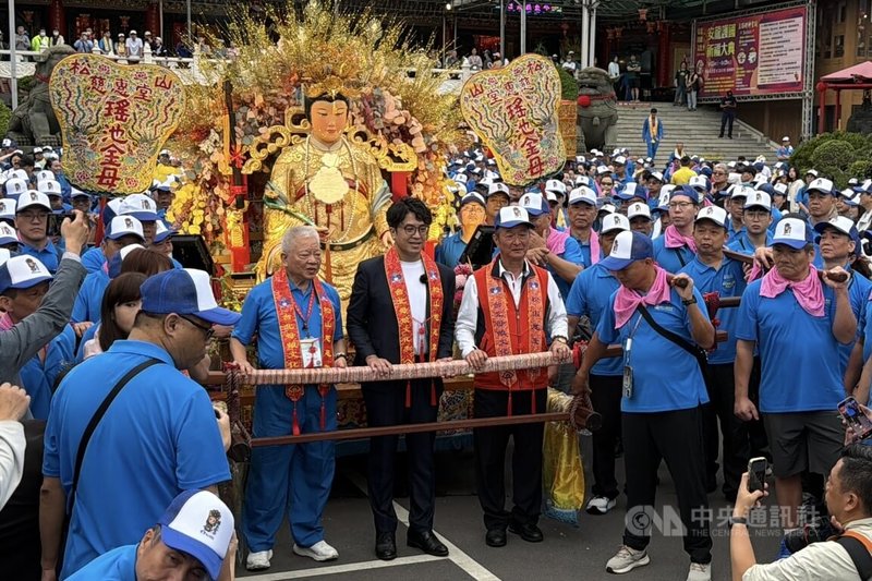 民進黨立委沈伯洋（中）25日上午到台北松山慈惠堂，出席「2026台北母娘文化季米龍開光暨神遊台北保民遶境嘉年華起駕」活動，參與扶轎。中央社記者徐肇昌攝 115年4月25日