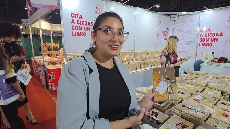 布宜諾斯艾利斯國際書展中，讀者蘇菲亞（Sofia）被盲書包裝吸引，在攤位前停留閱讀包裝上的手寫文字，成為她書展中具互動性的購書體驗之一。中央社記者黃韻如布宜諾斯艾利斯攝　115年4月25日