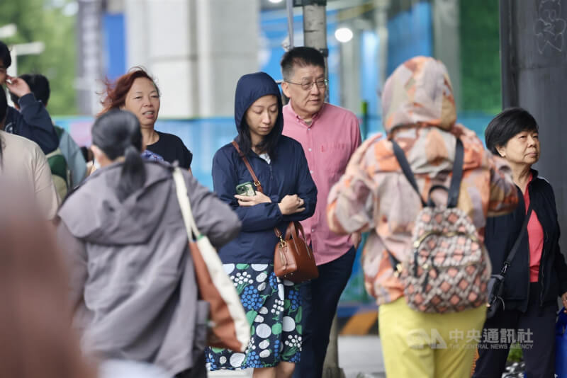 圖為台北市松山區街頭民眾身著薄外套。（中央社檔案照片）