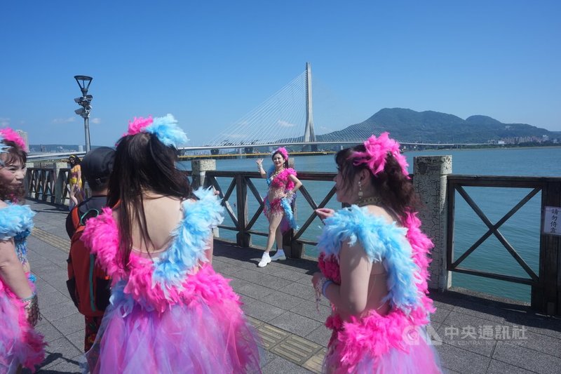 表演團體舞者26日參加淡江大橋開幕藝術「在一起，走上橋」大遊行，在活動開始前與淡江大橋合影。中央社記者徐肇昌攝 115年4月26日