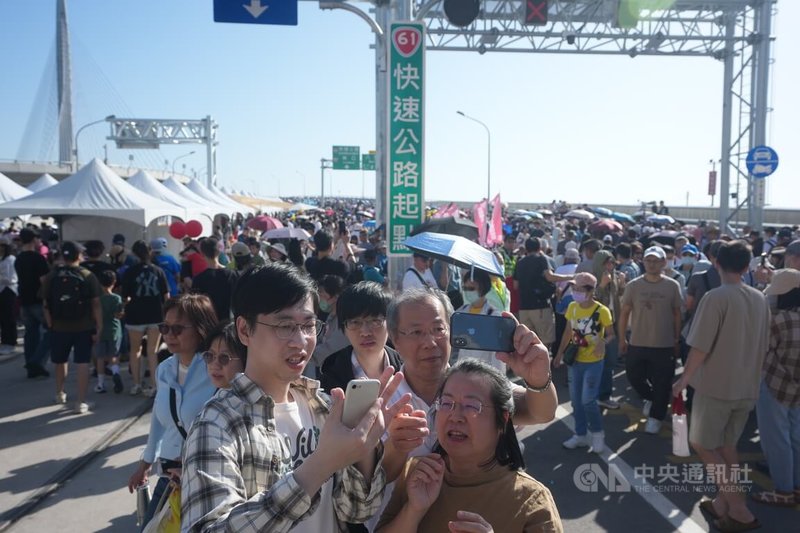 新北市淡江大橋開幕藝術季「在一起，走上橋」大遊行26日下午登場，邀請民眾一同走上橋面，見證世界級地標的壯麗，與會者在橋頭駐足自拍留念。中央社記者徐肇昌攝　115年4月26日