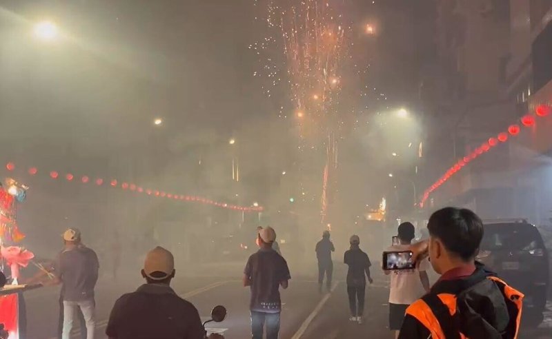高雄市鹽埕區某宮廟25日辦理遶境活動，期間燃放鞭炮產生大量粒狀污染物，影響交通行車視線，且有在禁止時段使用擴音設備影響安寧、炮屑未清除及亂丟煙蒂等行為，遭高雄市政府環保局及警消依法開罰。（高雄市政府消防局提供）中央社記者張已亷傳真　115年4月26日