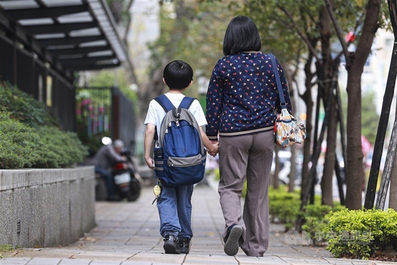 台北市政府推出「育兒減少工時」試辦計畫，提供12歲以下子女確有接送需求的家長申請減少1小時工時。圖為家長牽著孩子步行。(中央社檔案照片)