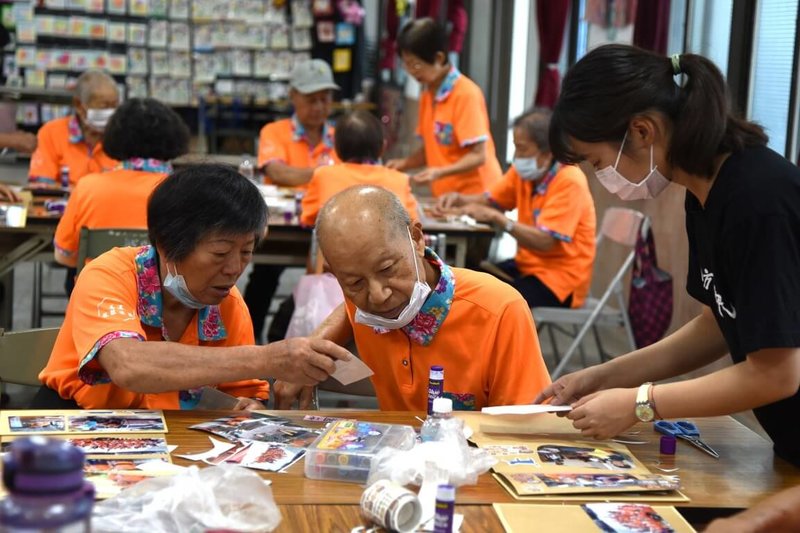 東華大學華文文學系學生黃靖珈（右）114年參與青年暑期社區職場體驗計畫，到高雄市小鄉社造志業聯盟見習，協助長輩製作相片手工書。（青年署提供）中央社記者許秩維傳真　115年4月29日