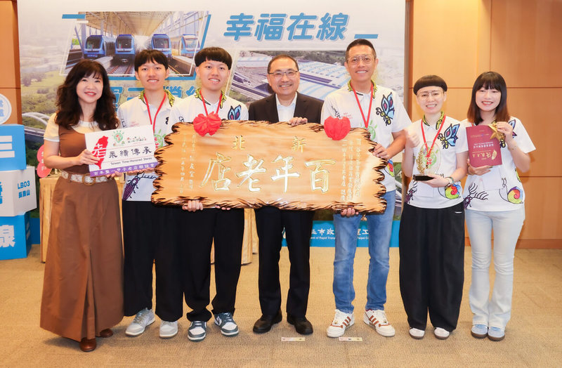 新北市三峽區「谷芳有機茶園」獲經濟部商業發展署「2025優良台灣老店–菁英老店」肯定，新北市長侯友宜（中）29日頒發匾額給茶園負責人李昌峻（右3）、洪佳玉（右2）等人。（新北市新聞局提供）中央社記者黃旭昇傳真　115年4月29日