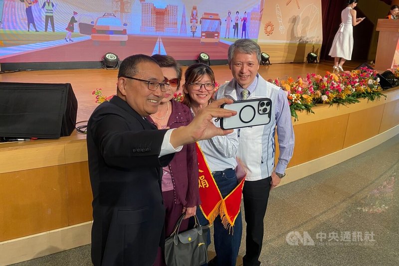 新北市勞工局與交通局30日共同舉辦「115年新北市模範勞工表揚大會」，市長侯友宜（左）親自到場頒獎表揚，並與獲獎者近距離互動、自拍致意。右為新北市勞工局長陳瑞嘉。中央社記者黃旭昇攝　115年4月30日