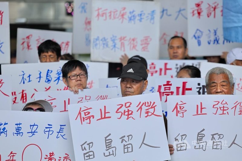 社子島自救會成員30日到台北市政府前舉行記者會，手舉「停止強徵」、「留島留人」等看板，要求市府停審開發案、重新擬定都市計畫。中央社記者王飛華攝　115年4月30日