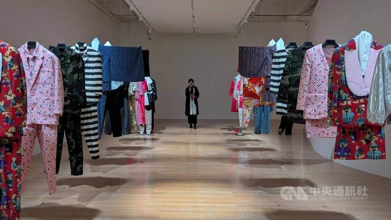 日本藝術家日下淳一作品「超越認同」以30套懸吊的改造服裝構成，其中如帶有監獄式粗直條紋的西裝外套，指向衣物不僅決定外在形象，更影響個體的思考與人格認同，5月1日將在台北市立美術館展出。中央社記者王寶兒攝　115年4月30日