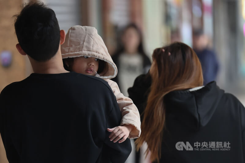 圖為台北市萬華區小朋友拉起帽子禦寒。（中央社檔案照片）