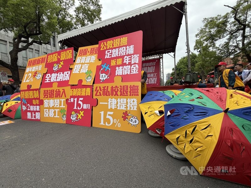五一勞工遊行1日登場，以「退休給付增加、本勞移工全保」為主軸，要求政府完善勞工退休制度，集會現場將8大訴求寫在拼圖上，並放置多把破傘，象徵現行退休保障制度漏洞百出。中央社記者吳欣紜攝　115年5月1日