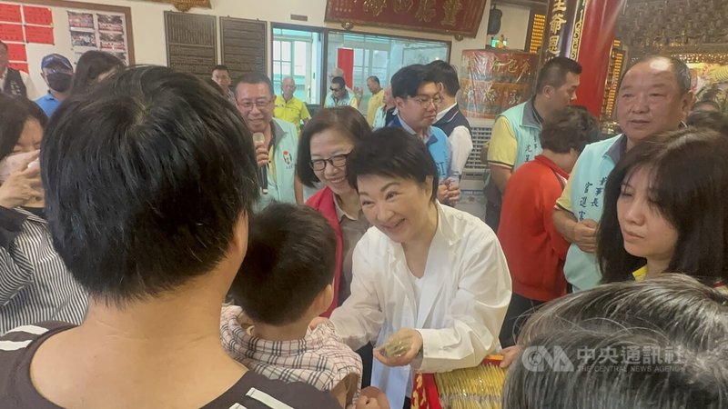台中市長盧秀燕（白衣者）1日到水安宮參拜並贈匾，現場發送「馬上賺」鑰匙圈，吸引民眾排隊索取。中央社記者趙麗妍攝　115年5月1日