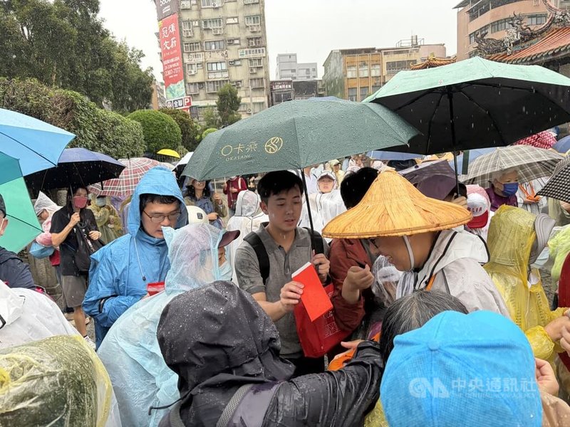 佛光山舉行「佛光山2026年傳授國際萬佛三壇大戒」，展開行腳托缽修持，台北區行動5日展開，行腳隊伍一啟程，信眾們一擁而上投缽供養。中央社記者吳欣紜攝　115年5月5日