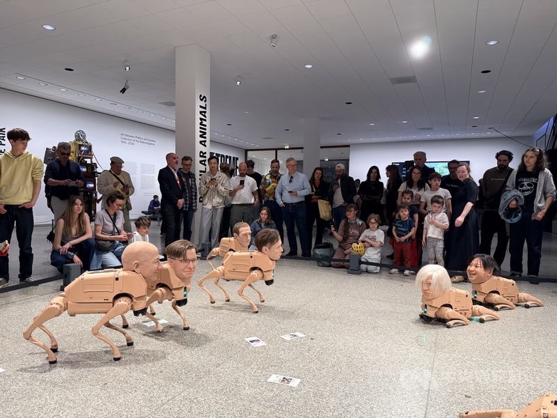 美國數位藝術家Beeple裝置作品「常規動物」於柏林新國家美術館展出，機器狗裝上獨裁者、改變世界審美的藝術家與科技巨頭臉孔，在展場中移動並透過人工智慧生成圖像，吸引觀眾圍觀。中央社記者林尚縈柏林攝　115年5月5日