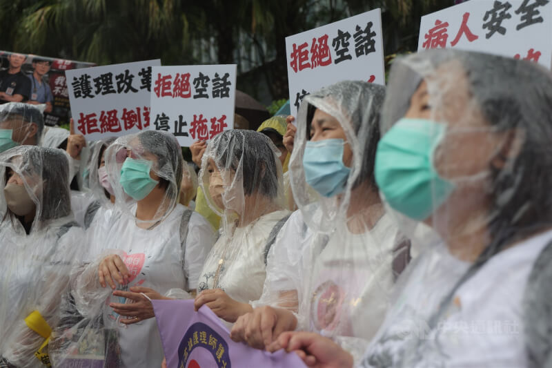 中華民國護理師護士公會全國聯合會5日發起抗議行動，許多護理人員冒雨在衛福部前聚集，高舉「拒絕空話 停止拖延」字卡，要求「三班護病比」須於5月20日前實質入法。中央社記者翁睿坤攝　115年5月5日
