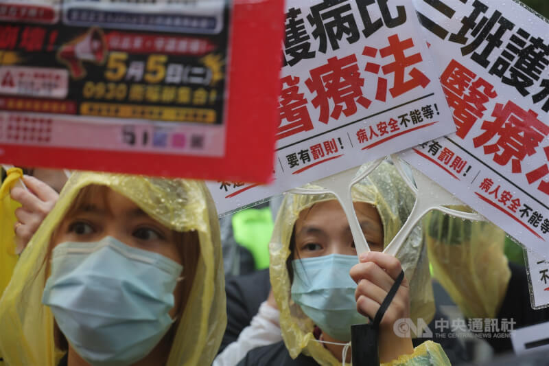 中華民國護理師護士公會全國聯合會5日發起抗議行動，大批護理人員穿著雨衣在衛福部前集結，拿著寫有「三班護病比入醫療法」的手舉牌表達訴求，呼籲病人安全不能等。中央社記者翁睿坤攝　115年5月5日