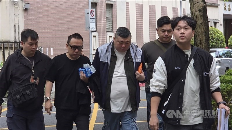 男子周文傑（中）涉嫌設立空殼貿易公司替詐欺及博弈集團洗錢，1年洗錢逾新台幣10億元。檢警獲報循線逮獲周男等12人，6日下午陸續移送北檢複訊。（中央社檔案照片）