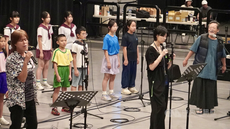 為準備即將登場的2026總統府音樂會，歌手吳永吉Kiat Táng（前左）、曹雅雯（前中）、陳明章（前右）7日與豐田國小合唱團在高雄駁二藝術特區合體排練。中央社記者董俊志攝　115年5月7日