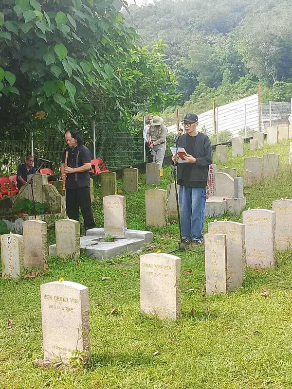 馬來西亞513種族衝突事件57週年，以「513事件」為背景的電影「五月雪」導演張吉安（右）9日在雙溪毛糯513墓園公祭儀式中吟誦追悼詩，追念罹難者。（隆雪歷史與文化資產之友協會秘書劉敬提供）中央社記者黃自強吉隆坡傳真　115年5月10日