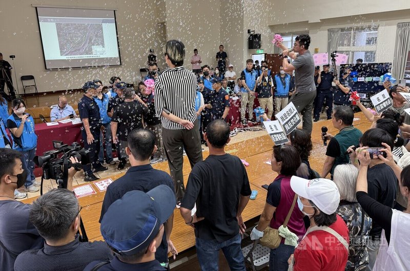南投縣政府12日召開垃圾處理中心二階環評範疇界定會議,名間鄉反焚化爐自救會等團體到場,反對者一度越過桌子遭警方攔阻,還有民眾站上桌噴泡泡。中央社記者蕭博陽南投縣攝 115年5月12日