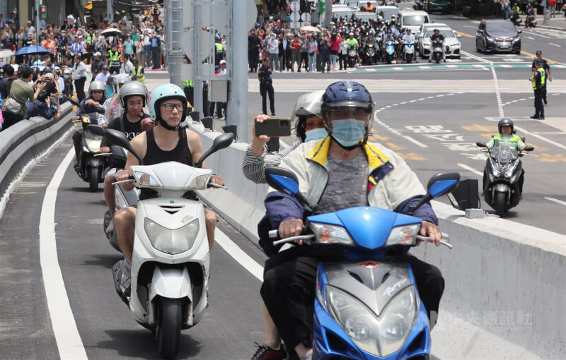 許多機車騎士在通車第一時刻上橋體驗,後座乘客拿起手機拍照記錄。中央社記者趙世勳攝 115年5月12日
