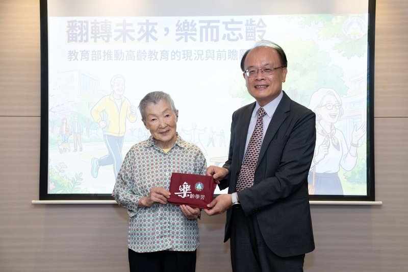 來自日本、高齡91歲的若宮正子（左）13日訪問教育部，終身教育司司長梁學政（右）贈送樂齡小書包。（教育部提供）中央社記者陳至中台北傳真　115年5月13日
