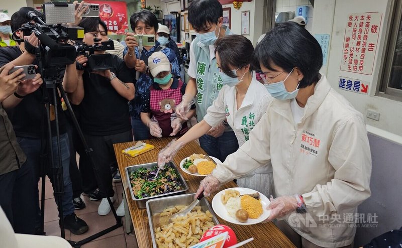 民進黨新北市長參選人、立委蘇巧慧(右)13日出席板橋區後埔里長者共餐活動,現場「凍蒜」聲不斷,她也當起打菜手,幫長者打菜。中央社記者王鴻國攝 115年5月13日
