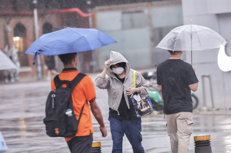 圖為台北西門町商圈民眾撐傘擋雨。（中央社檔案照片）
