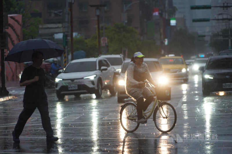 鋒面逐漸南下，13日由北而南各地轉為有陣雨或雷雨的天氣型態，氣象專家也提醒需留意瞬間強降雨，外出應備雨具。台北市區午後天色昏暗、雨勢不斷，外出民眾快步過馬路。中央社記者裴禛攝  115年5月13日