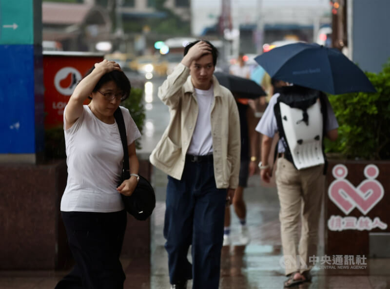 氣象專家吳德榮表示，鋒面13日逐漸南下，由北而南各地轉有陣雨或雷雨，提醒民眾留意瞬間強降雨。圖為台北車站周邊民眾在雨中用手遮擋雨水。（中央社檔案照片）