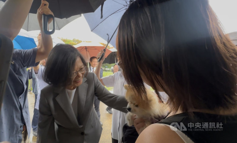 前總統蔡英文（左）14日到東海大學演講，有民眾帶著毛小孩前來，蔡英文開心上前逗弄狗狗。她在演講中也分享自己飼養寵物點滴，因寵物不會回嘴，互動時讓她感到很紓壓。中央社記者趙麗妍攝 115年5月14日