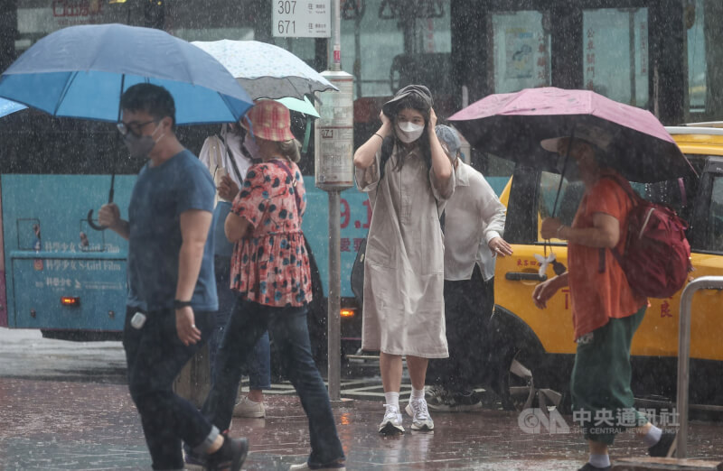 台北車站周邊有民眾未攜帶雨具，以衣物擋雨。（中央社檔案照片）