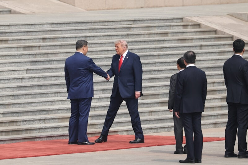 中國國家主席習近平（左）在人民大會堂外迎接美國總統川普（左2），兩人握手數分鐘。（路透社）