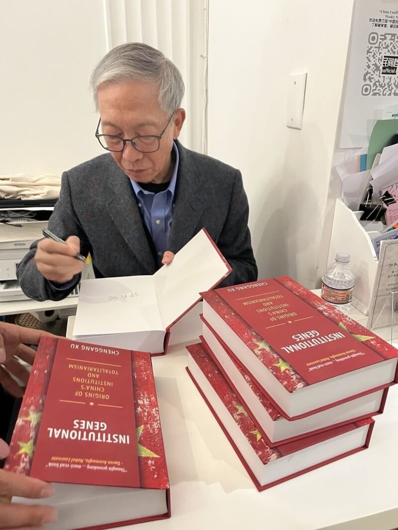 中國經濟學者許成鋼在美國華府季風書園為自己的著作Institutional Genes(英文版「制度基因」)簽名,這本書從探討中國政經制度和極權主義的起源。(許成鋼提供)中央社台北傳真 115年5月17日