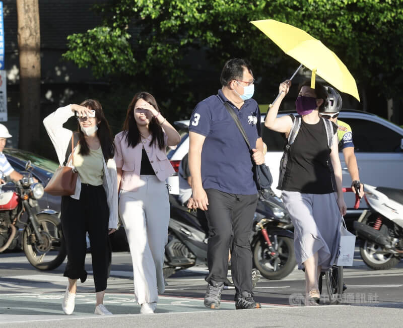 圖為北市大稻埕碼頭民眾撐傘或以手遮擋陽光。（中央社檔案照片）