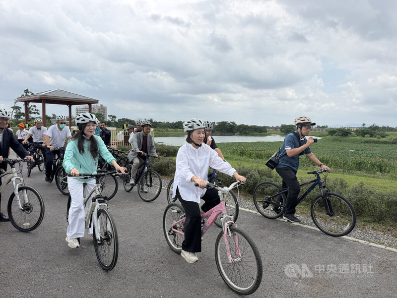 屏東武洛溪大仁支線滯洪池環境營造工程18日啟用,縣長周春米(前中)騎乘自行車,環繞大仁滯洪池環湖通道,歡迎民眾多加利用前來休憩。中央社記者李卉婷攝 115年5月18日