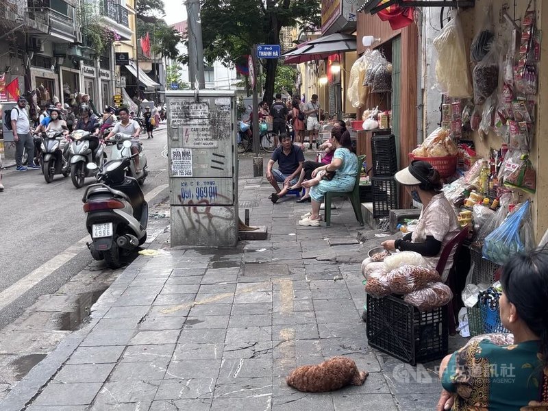 河內近月嚴厲取締占用人行道。週末下午，老城區的傳統市場人聲鼎沸，少數人有習慣坐在走道上，但和過去比起來已相當「克制」，但有些小店家與流動攤販因此生計受損。中央社記者曾婷瑄河內攝　115年5月18日