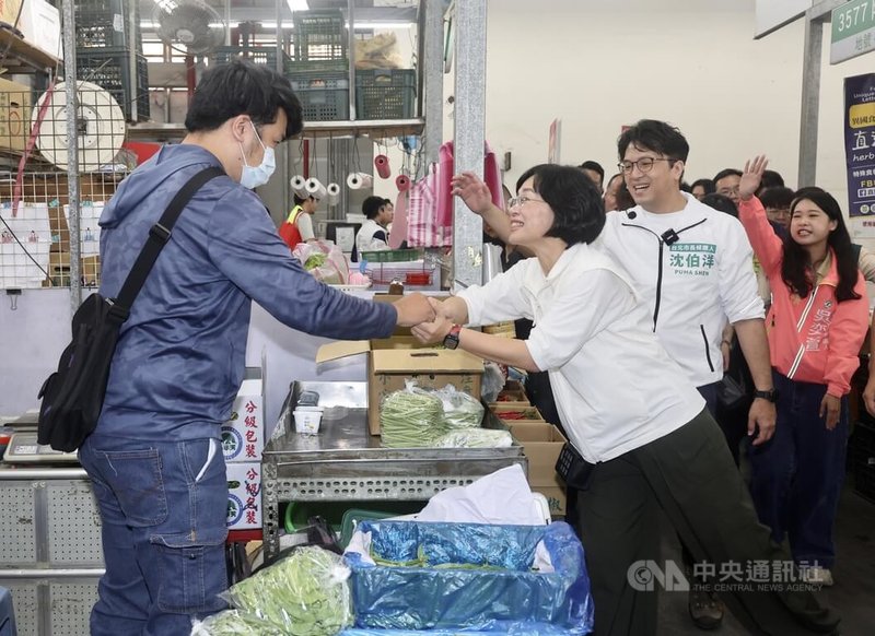 民進黨台北市長參選人沈伯洋（左3）、新北市長參選人蘇巧慧（左2）19日清晨前往台北市第一果菜批發市場拜票，與攤商握手問候、揮手致意。中央社記者張皓安攝　115年5月19日