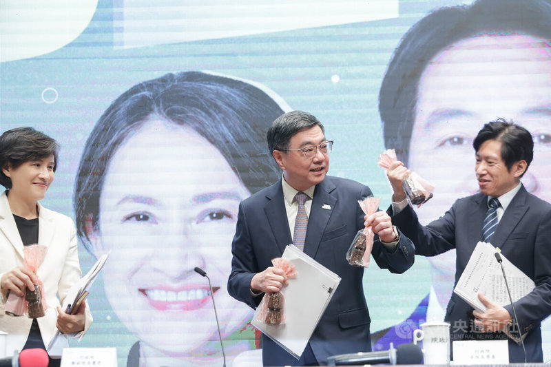 行政院長卓榮泰(中)、副院長鄭麗君(左)及祕書長張惇涵(右)19日上午出席行政院520記者會,說明過去一年來內閣團隊施政成果,現場準備可麗露發送,象徵執政團隊向製作甜點一樣,用專業與毅力為國家打造一條康莊大道。中央社記者裴禛攝 115年5月19日
