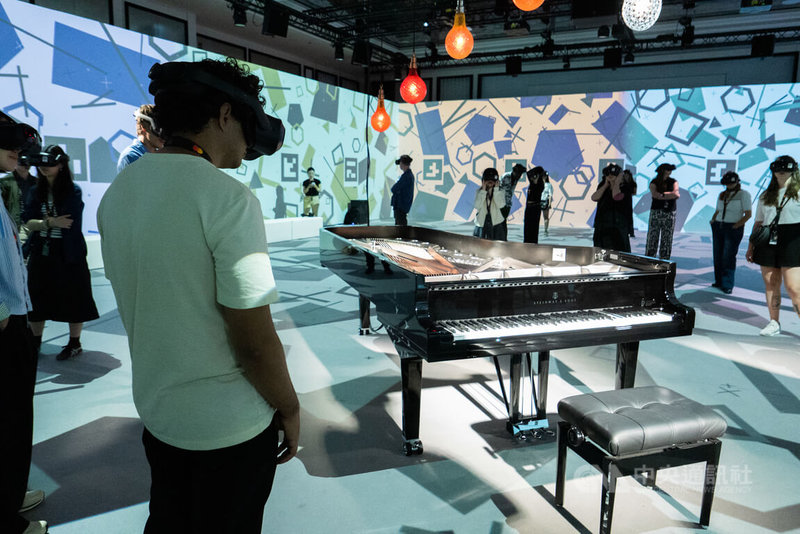 「與火共舞:王羽佳鋼琴藝術沉浸展」使用「混合實境」技術,讓虛擬影像中的鋼琴家指尖,完美融合在正自動彈奏的真實琴鍵上,並讓整體空間化身為以火為題的虛擬世界。此圖攝於5月13日坎城沉浸式競賽「與火共舞」放映現場。中央社記者李若韻坎城攝 115年5月22日