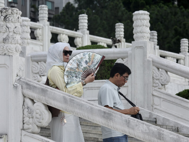 圖為中正紀念堂遊玩民眾在戶外搧扇子消暑。（中央社檔案照片）