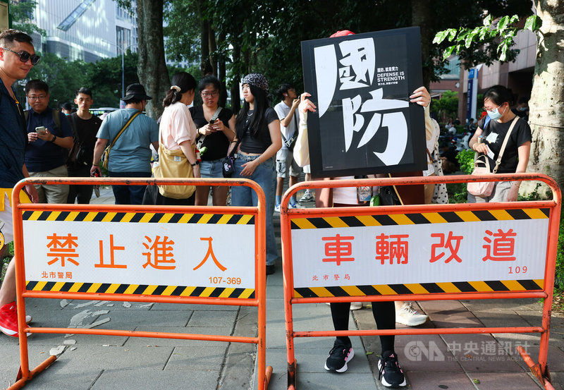 台灣公民陣線、台灣經濟民主連合等團體23日在台北舉行「真和平,要國防」遊行,終點處也有民眾手持標語聲援。中央社記者謝佳璋攝 115年5月23日