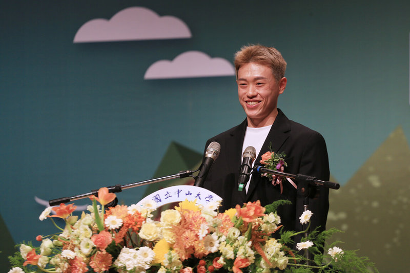 國立中山大學23日舉行2026年畢業典禮，邀請羽球國手林俊易（圖）致詞分享，他以自身從低潮到奪冠的歷程，勉勵畢業生。（中山大學提供）中央社記者林巧璉傳真　115年5月23日