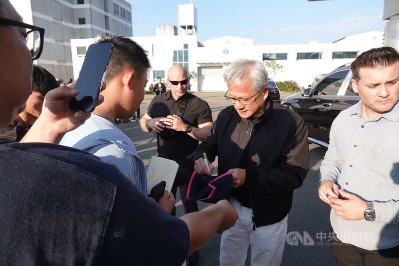 輝達執行長黃仁勳（右2）23日下午搭乘私人專機抵台，在松山機場商務中心外幫熱情守候的民眾簽名。中央社記者吳書緯攝　115年5月23日
