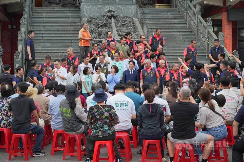 總統賴清德（立者前中右）23日南下屏東，首站先前往屏東市代天宮贈匾並與民眾互動，受到熱情歡迎。立者前中左為屏東縣長周春米。中央社記者黃郁菁攝　115年5月23日