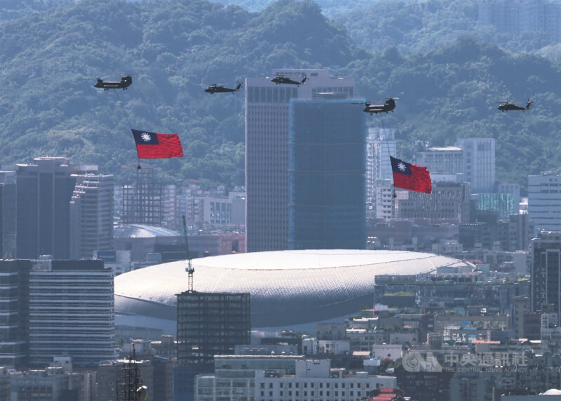 115年雙十國慶，國旗機隊吊掛巨幅國旗從松山機場起飛，越過台北市區上空。（中央社檔案照片）